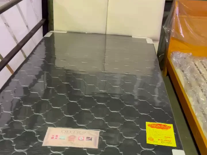 倉庫に置かれたシングルベッドと値札